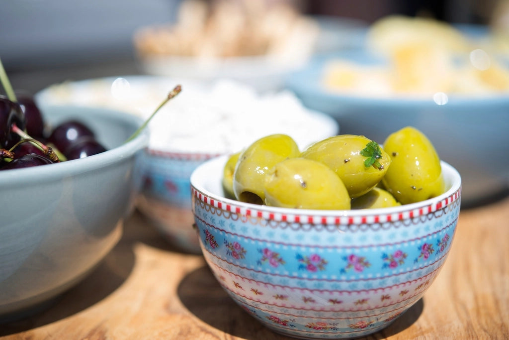 Bowl of green olives on a wooden table