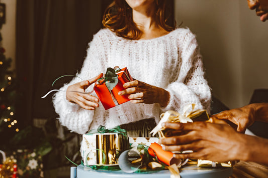 Friends exchanging wrapped holiday gifts at a party