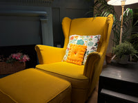 Cheese cracker plush pillow on a yellow armchair with a floral cushion